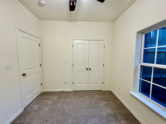 unfurnished bedroom featuring carpet floors, a closet, and ceiling fan