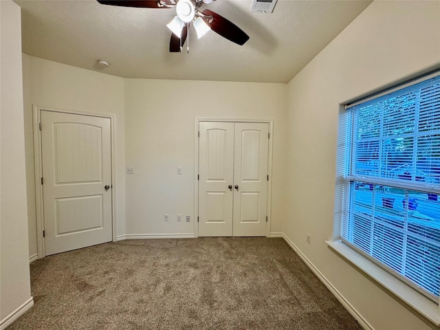 unfurnished bedroom featuring carpet flooring, ceiling fan, a textured ceiling, and a closet