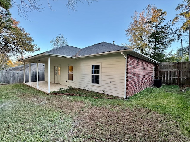 back of property featuring a patio area and a lawn