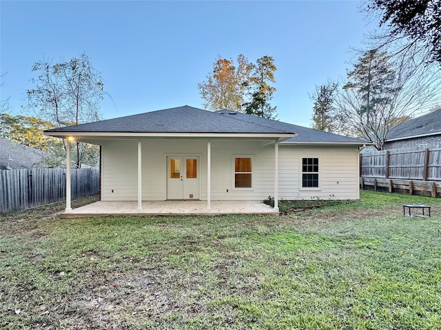 back of house featuring a patio area and a lawn