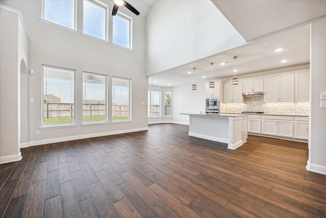 unfurnished living room featuring dark hardwood / wood-style floors and a healthy amount of sunlight