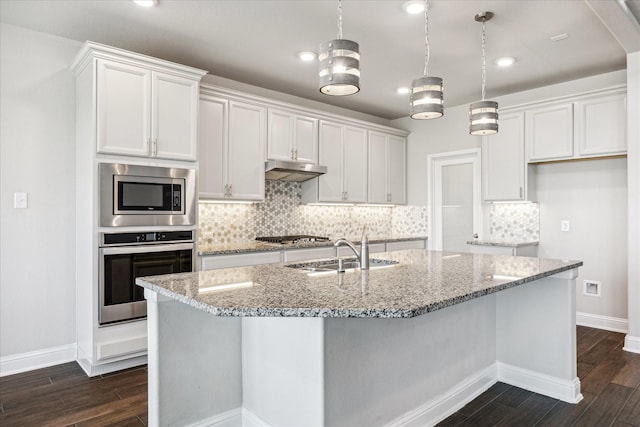 kitchen with light stone countertops, sink, white cabinets, and appliances with stainless steel finishes