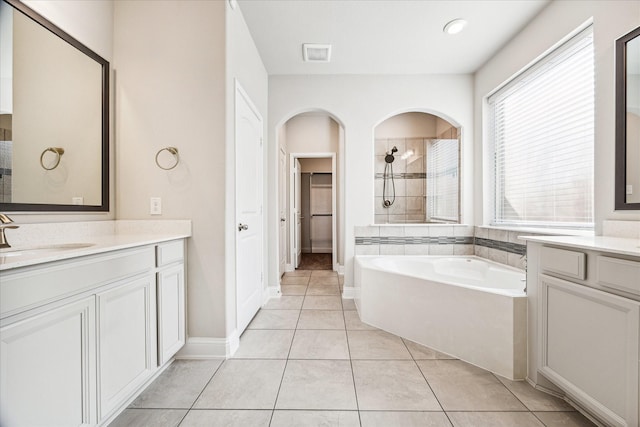 bathroom featuring plus walk in shower, vanity, and tile patterned floors