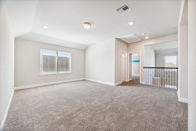 spare room featuring carpet flooring and vaulted ceiling