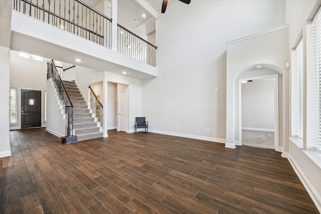 unfurnished living room with dark hardwood / wood-style flooring and a high ceiling