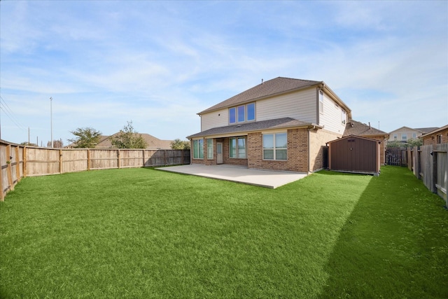 rear view of property with a lawn, a storage shed, and a patio