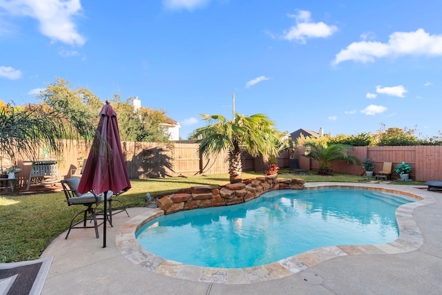 view of pool featuring a lawn and a patio