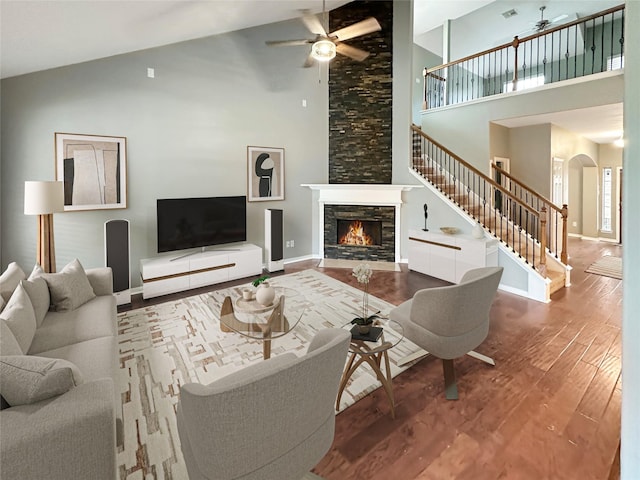 living room featuring a fireplace, hardwood / wood-style floors, and high vaulted ceiling