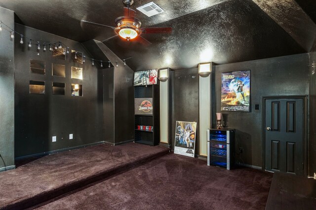 carpeted cinema room featuring a textured ceiling, ceiling fan, and lofted ceiling