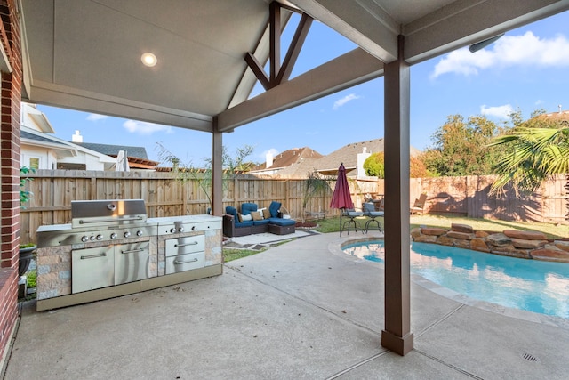 view of patio with outdoor lounge area, an outdoor kitchen, a fenced in pool, and area for grilling