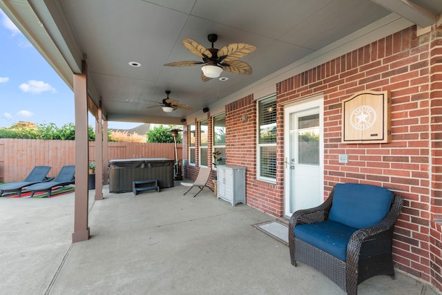 view of patio with ceiling fan and a hot tub