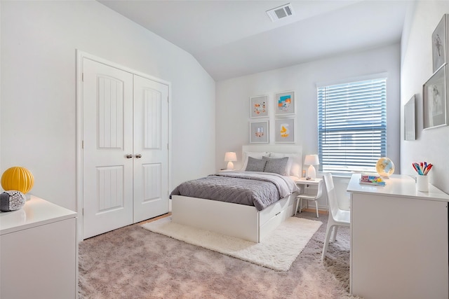 bedroom featuring light carpet, a closet, and vaulted ceiling