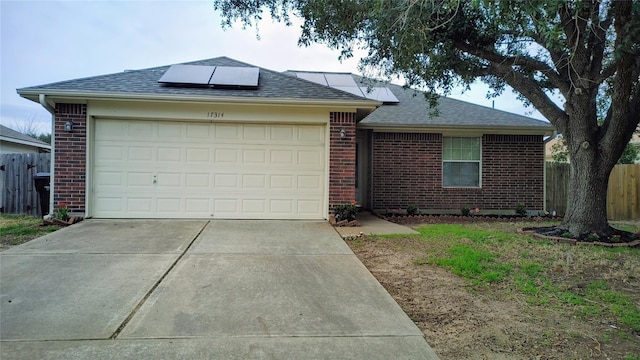 ranch-style home with solar panels and a garage