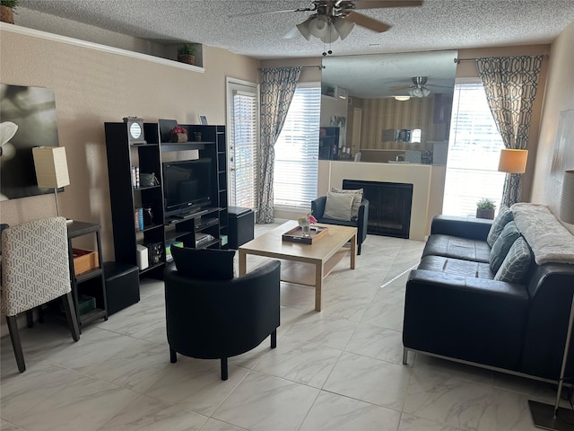 living room featuring ceiling fan and a textured ceiling