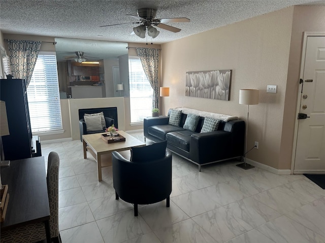 living room with ceiling fan and a textured ceiling