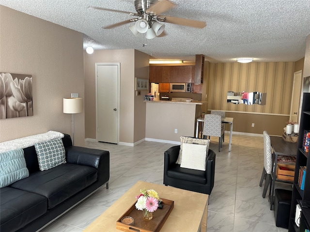 living room with a textured ceiling and ceiling fan