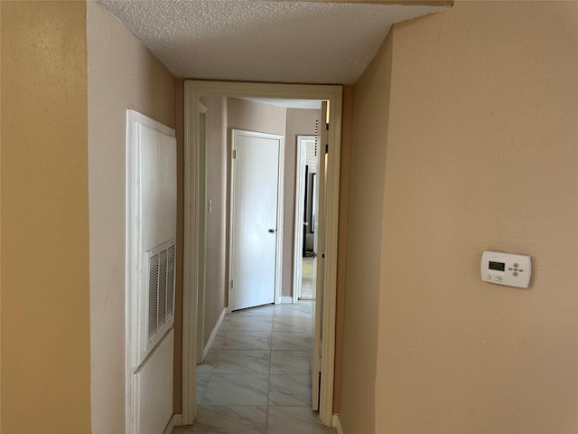 hallway with a textured ceiling