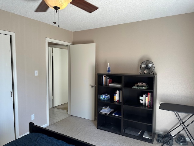 carpeted bedroom featuring a textured ceiling and ceiling fan