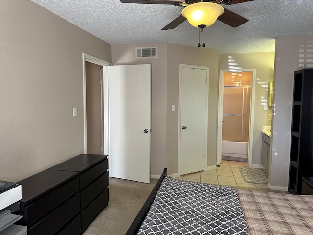 bedroom with connected bathroom, ceiling fan, light carpet, and a textured ceiling