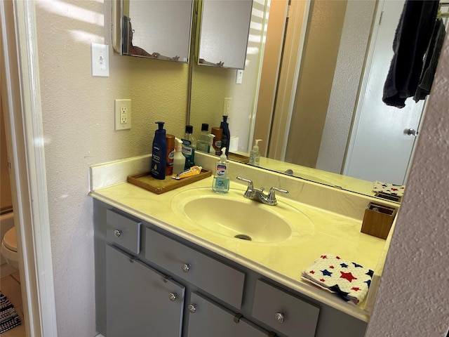 bathroom featuring vanity and toilet