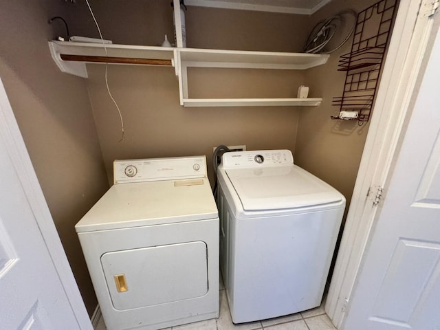 clothes washing area with separate washer and dryer and light tile patterned floors