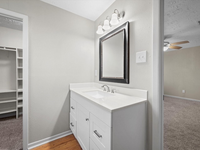 bathroom featuring ceiling fan, vanity, and a textured ceiling