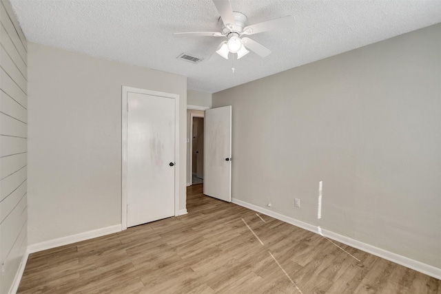 unfurnished bedroom featuring ceiling fan, light hardwood / wood-style flooring, and a textured ceiling