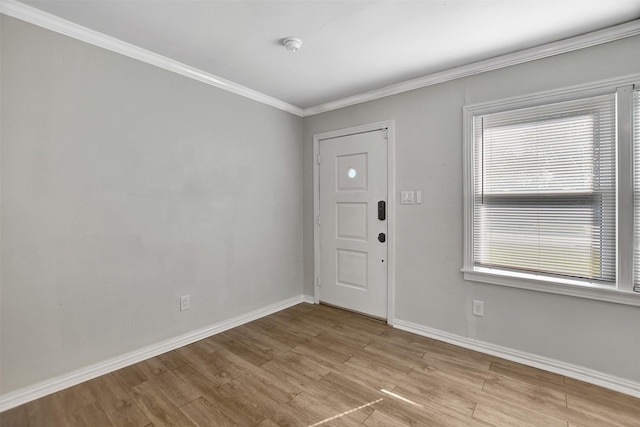 entryway with ornamental molding and light hardwood / wood-style flooring