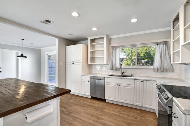 kitchen with pendant lighting, wood counters, sink, white cabinetry, and stainless steel appliances