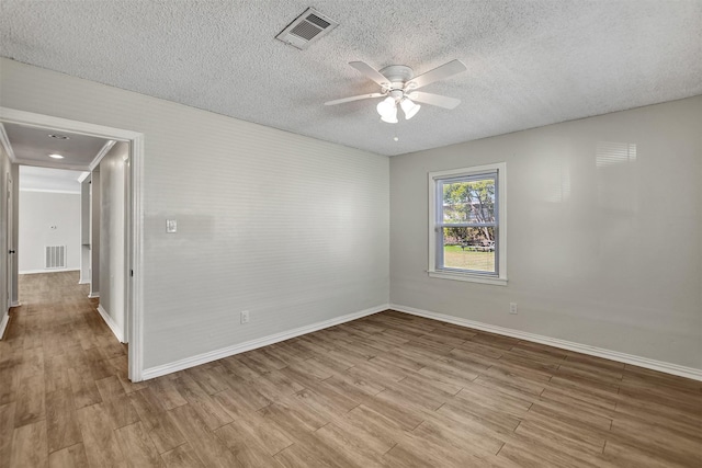 empty room with a textured ceiling, light hardwood / wood-style flooring, and ceiling fan