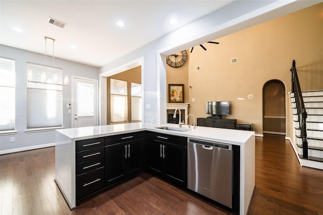 kitchen featuring dark hardwood / wood-style flooring, sink, pendant lighting, a center island with sink, and dishwasher