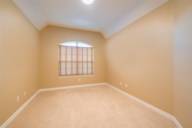 spare room featuring carpet flooring and lofted ceiling