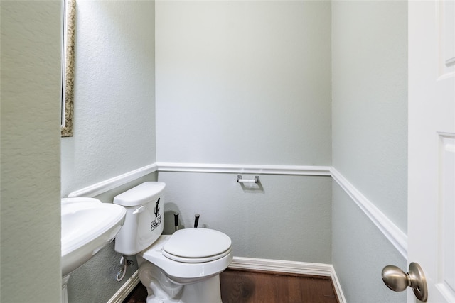 bathroom featuring hardwood / wood-style flooring and toilet