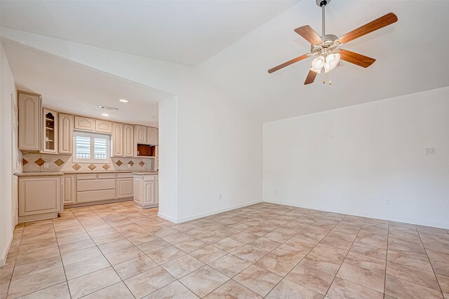 unfurnished living room featuring ceiling fan, light tile patterned floors, and vaulted ceiling