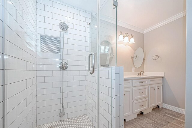 bathroom featuring hardwood / wood-style flooring, vanity, an enclosed shower, and ornamental molding