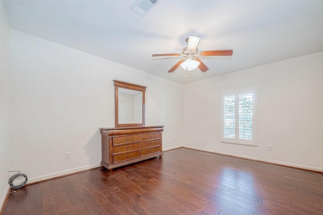 empty room with dark hardwood / wood-style flooring and ceiling fan