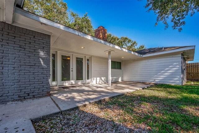 rear view of property with french doors and a yard