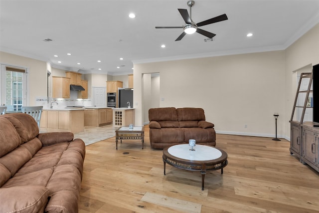 living room with crown molding, sink, ceiling fan, and light hardwood / wood-style floors