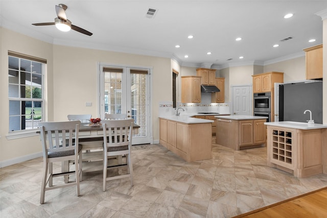 kitchen with a center island, ceiling fan, ornamental molding, appliances with stainless steel finishes, and kitchen peninsula