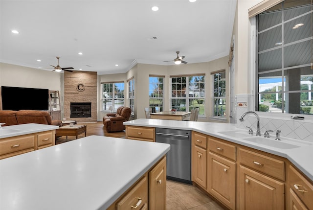 kitchen with dishwasher, ornamental molding, a fireplace, and a wealth of natural light