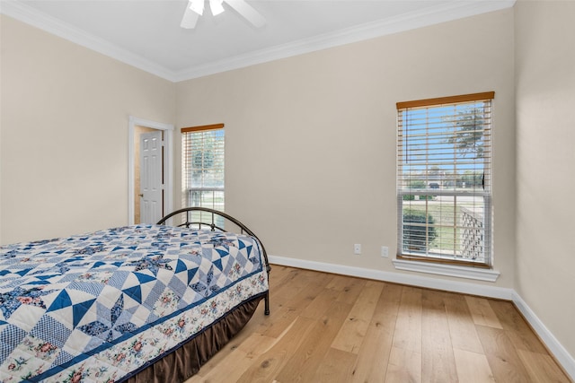 bedroom with ceiling fan, light wood-type flooring, ornamental molding, and multiple windows