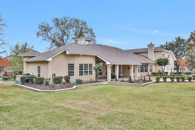 back of property with a yard and a patio