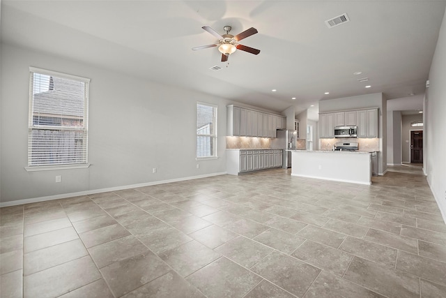 unfurnished living room with plenty of natural light and ceiling fan