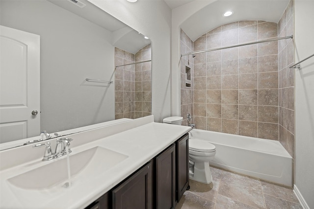 full bathroom with vanity, tiled shower / bath combo, and toilet