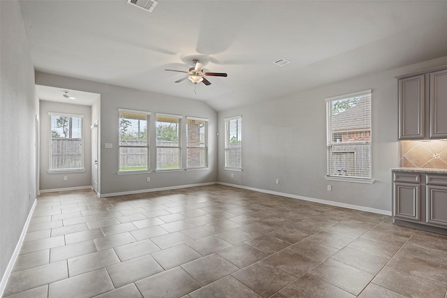 unfurnished room with ceiling fan, lofted ceiling, and a wealth of natural light