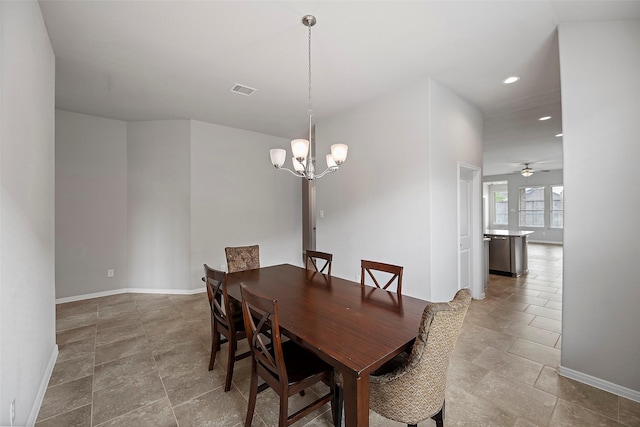 dining area featuring ceiling fan with notable chandelier