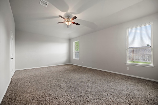 carpeted spare room featuring plenty of natural light and ceiling fan