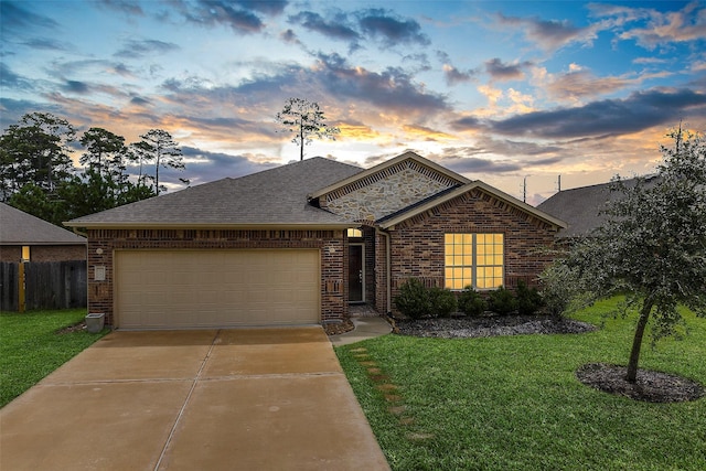 ranch-style home featuring a lawn and a garage