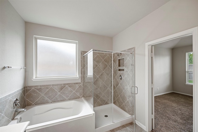 bathroom featuring shower with separate bathtub