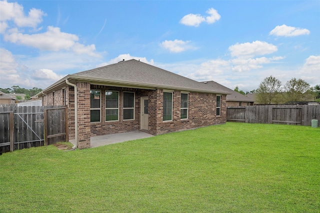 back of house with a patio area and a yard